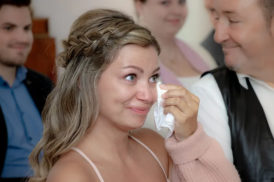 Hochzeitsgast wischt sich Freudentränen weg, emotionaler Moment bei der Trauung