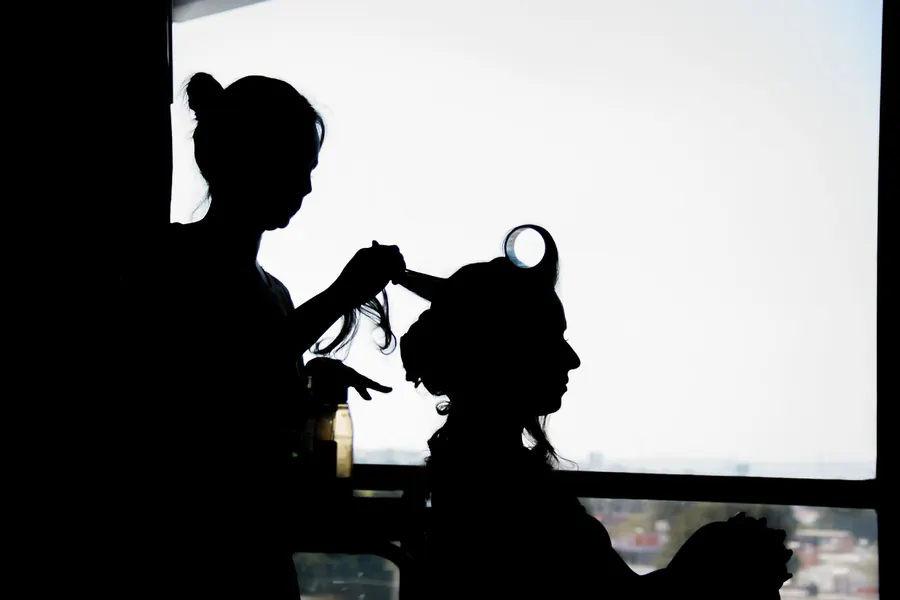 Silhouette der Braut beim Getting Ready am Fenster, Hochzeitsvorbereitung am Morgen