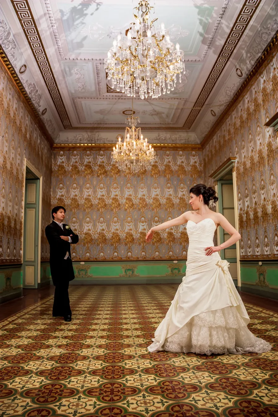 Braut tanzt im historischen Ballsaal unter Kristalllüstern, elegante Schlosshochzeit